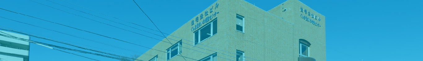 介護施設の建物外観。白色の壁面に窓が規則正に配置された多層建築。